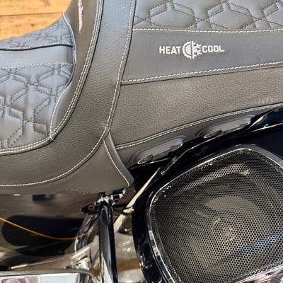 Motorcycle seat with 'Heat Cool' branding and a speaker grille.