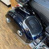 Close-up of a motorcycle seat with a speaker enclosure on a wooden floor.