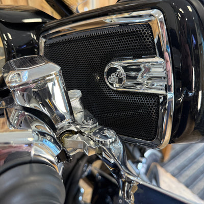 Close-up of a motorcycle engine with chrome parts and a brand logo.
