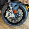 Close-up of a motorcycle wheel with visible branding on a wooden floor.