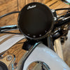 Motorcycle handlebar with an 'Indian' branded control panel on a wooden surface.
