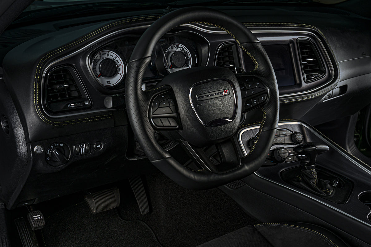 Steering wheel and dashboard of a vehicle with a prominent logo.