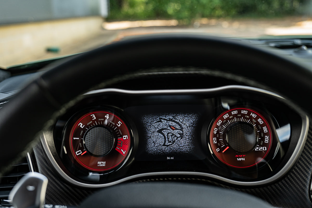 Car dashboard with red and black gauges and a digital display.