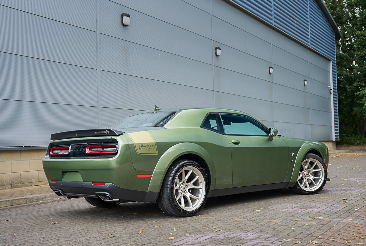 Green sports car parked in front of a gray building