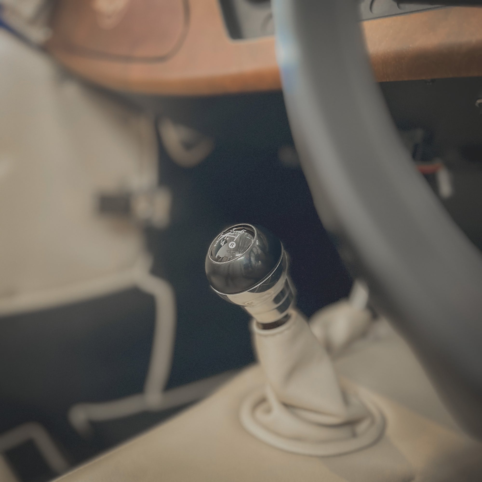 Close-up of a car gear shift lever with a blurred interior background