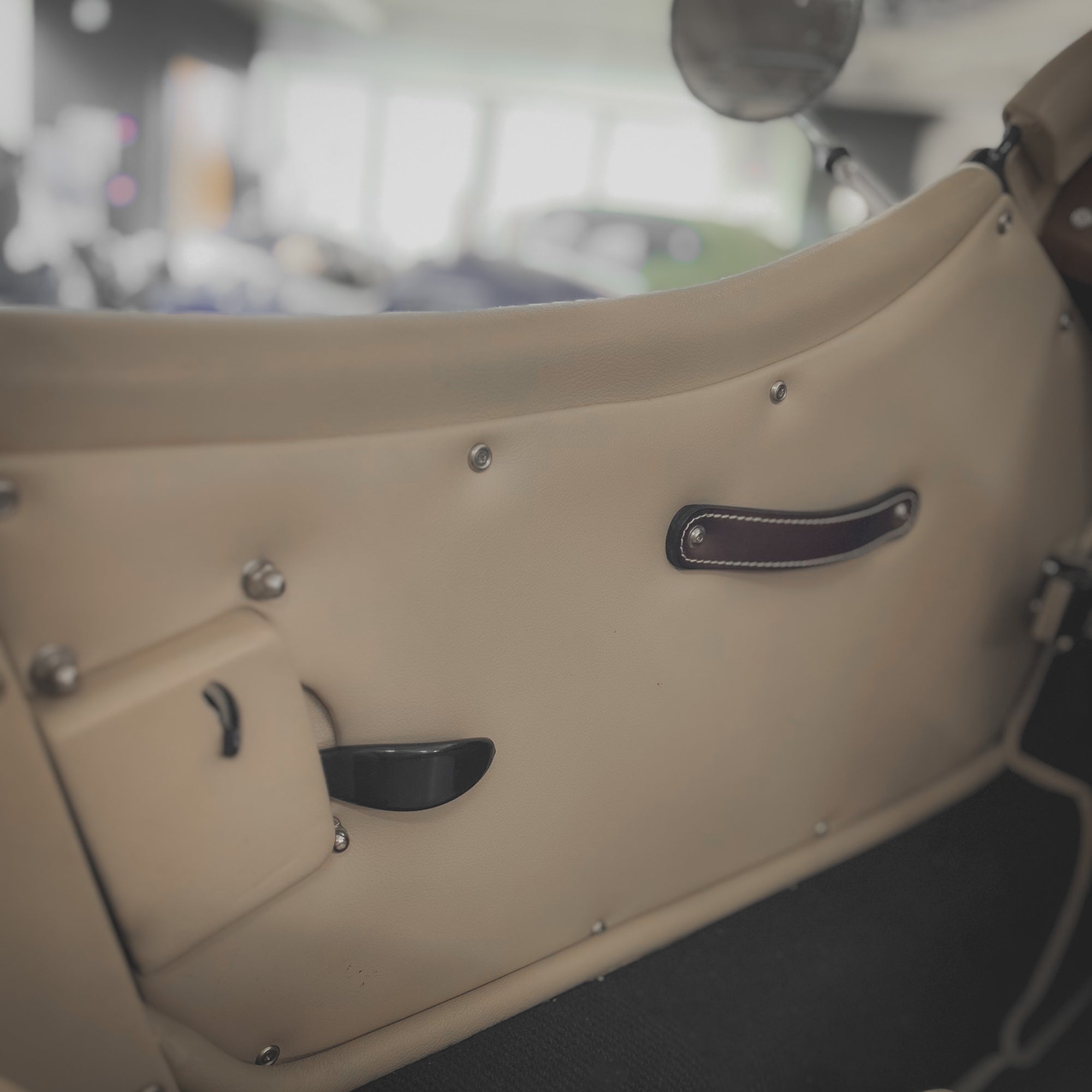 Close-up of a vintage car door with a blurred background