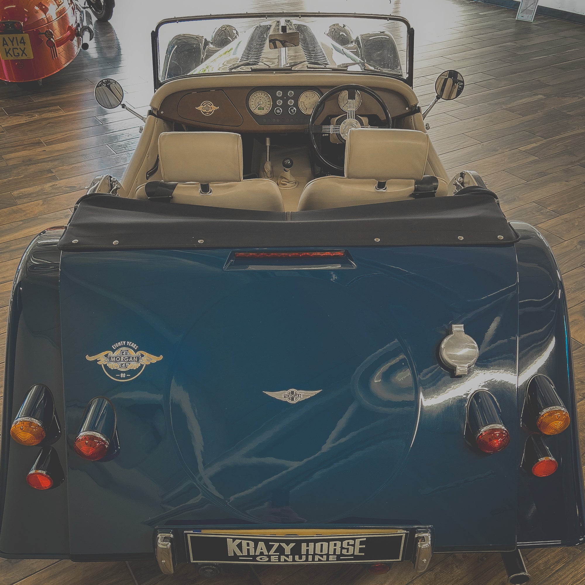 Vintage blue car with 'Krazy Horse' branding on a wooden floor.