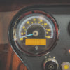 Close-up of a vehicle's speedometer and tachometer with needle pointing towards 0 mph.