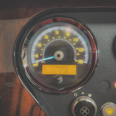 Close-up of a vehicle's speedometer and tachometer with needle pointing towards 0 mph.