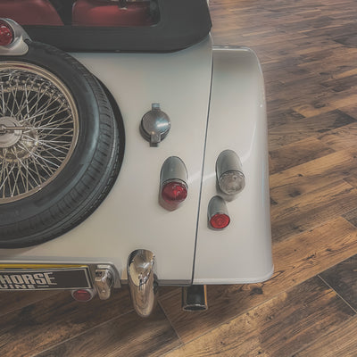 Small vehicle with a tire and visible components on a wooden floor
