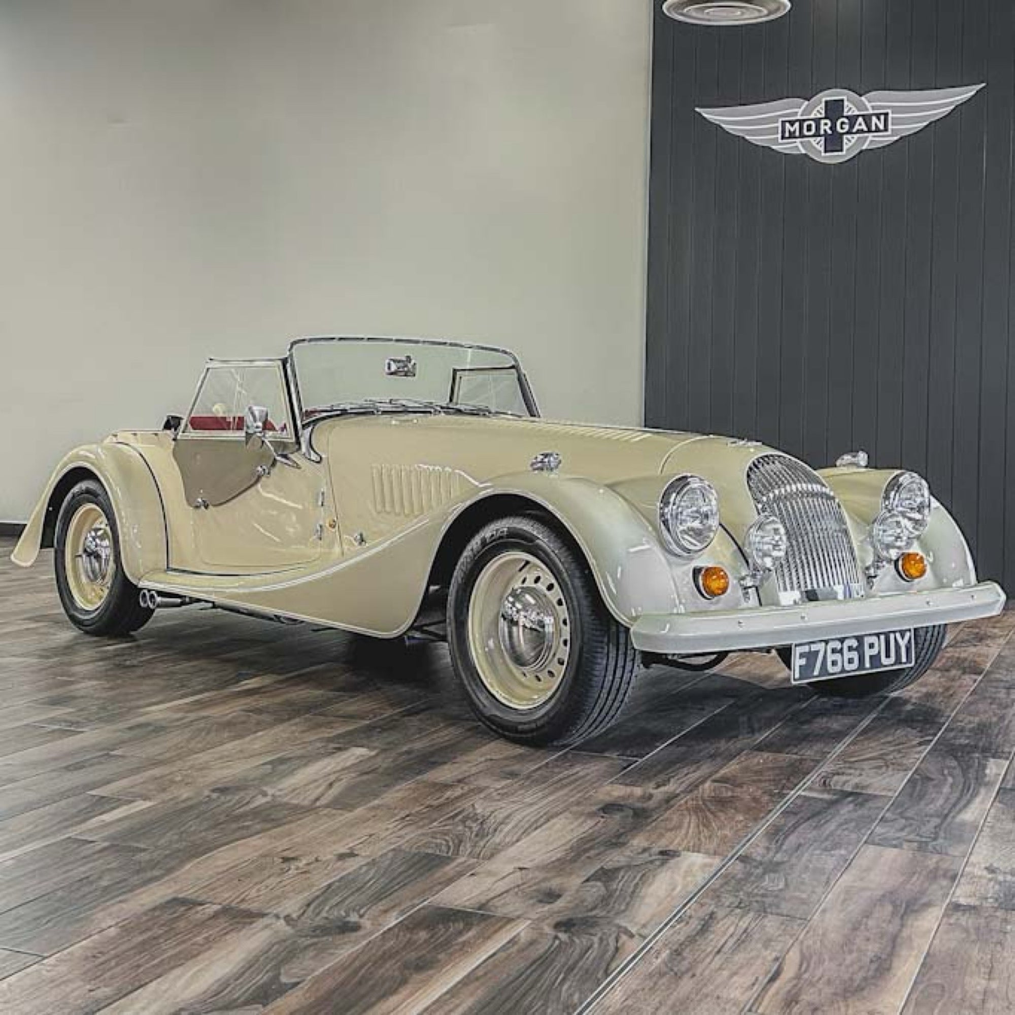 Vintage car on display with a branded wall in the background