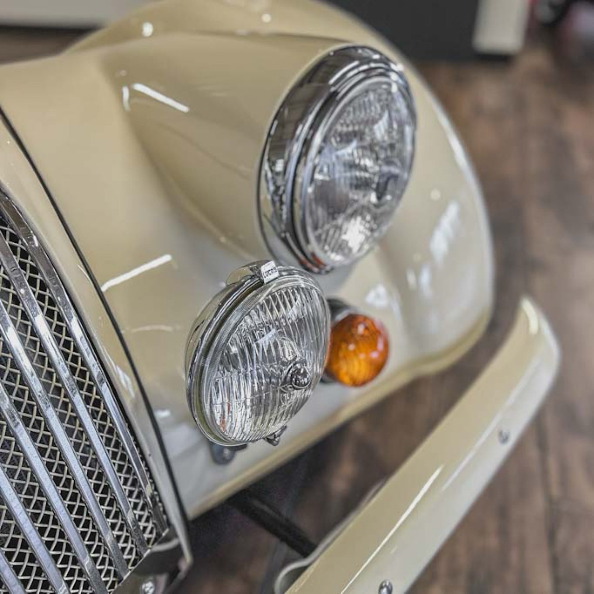 Close-up of a vintage car's front lights and grille.