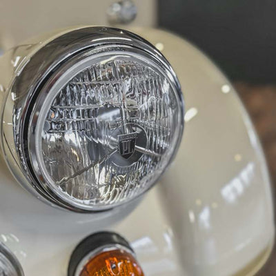 Close-up of a motorcycle headlight with visible brand logo.