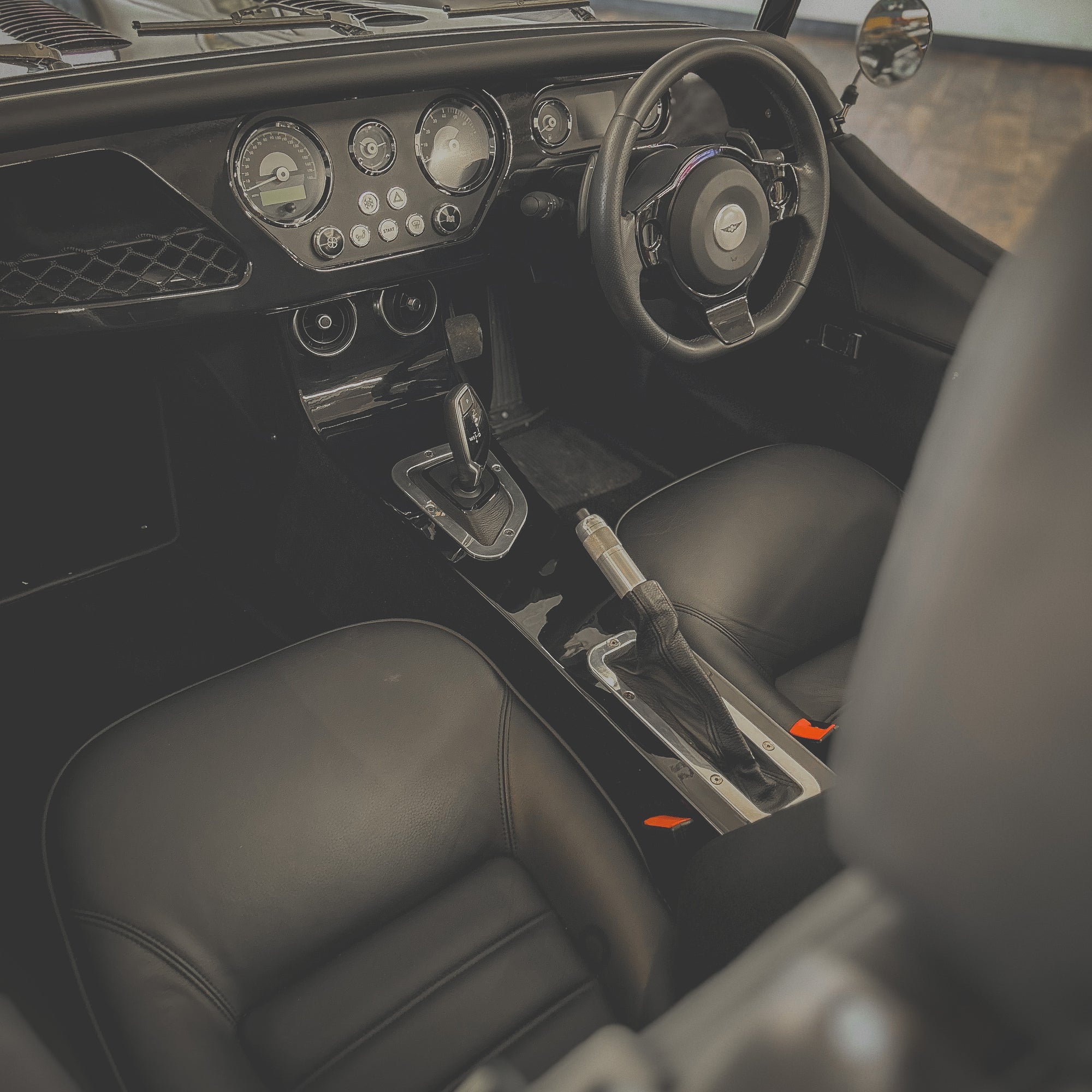 Car interior with dashboard, steering wheel, and gear shift.