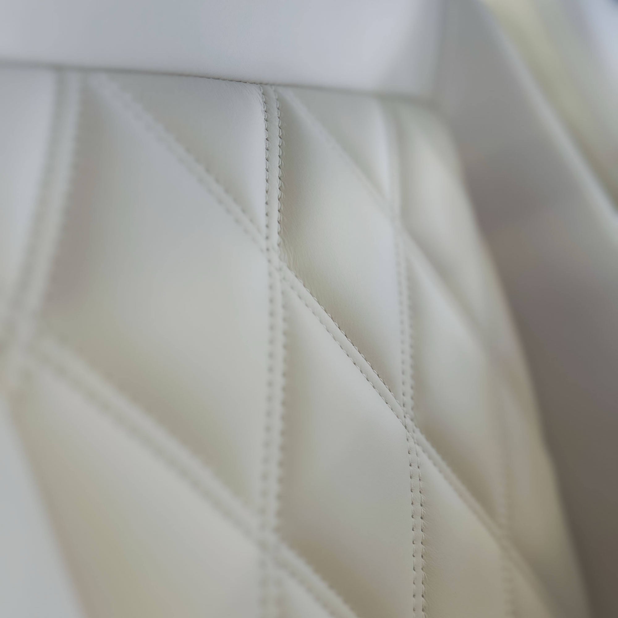 Close-up of a white quilted surface with geometric pattern