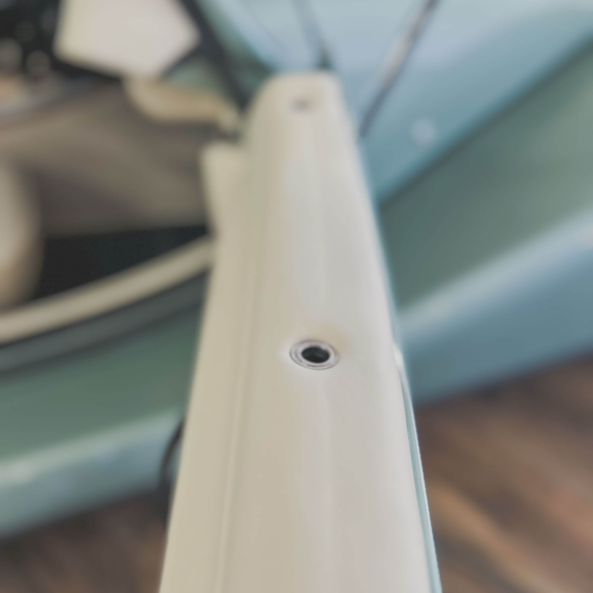 Close-up of a white chair arm with a blurred background