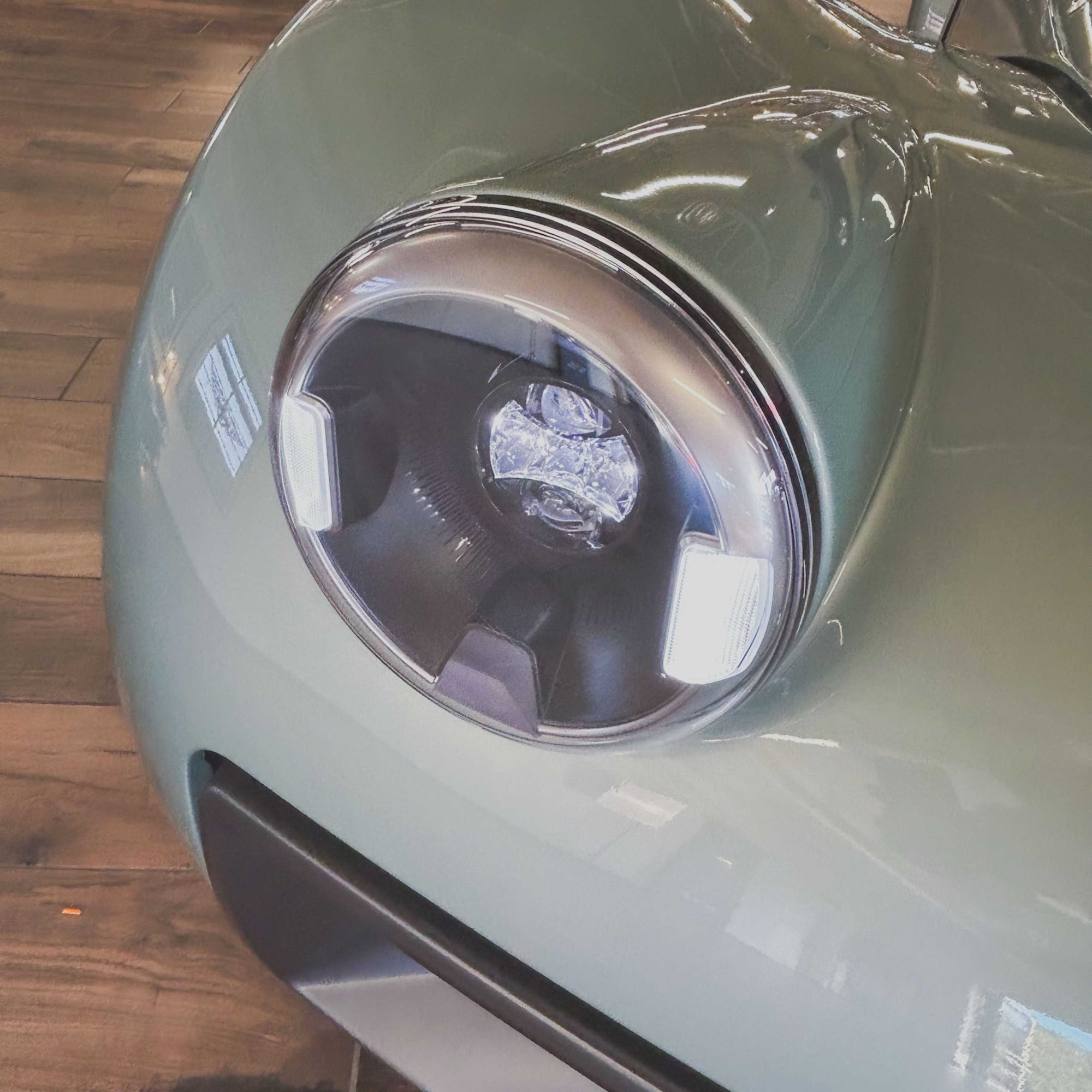 Close-up of a car's headlight on a wooden floor