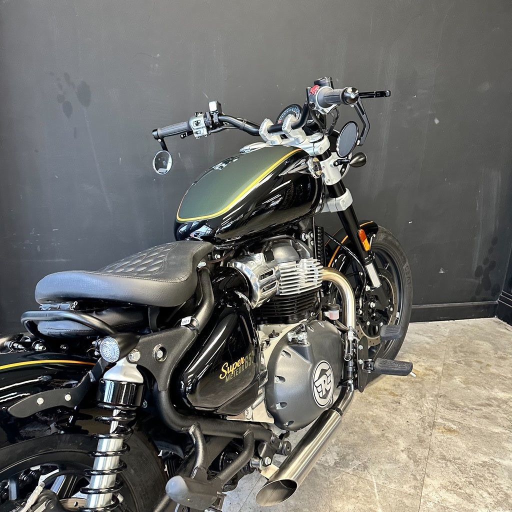 Black motorcycle with chrome details against a dark wall