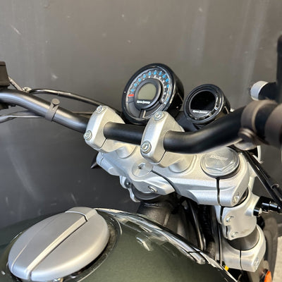 Close-up of a motorcycle handlebar with controls against a neutral background
