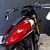 Red motorcycle with a black and white design on the fuel tank against a dark background