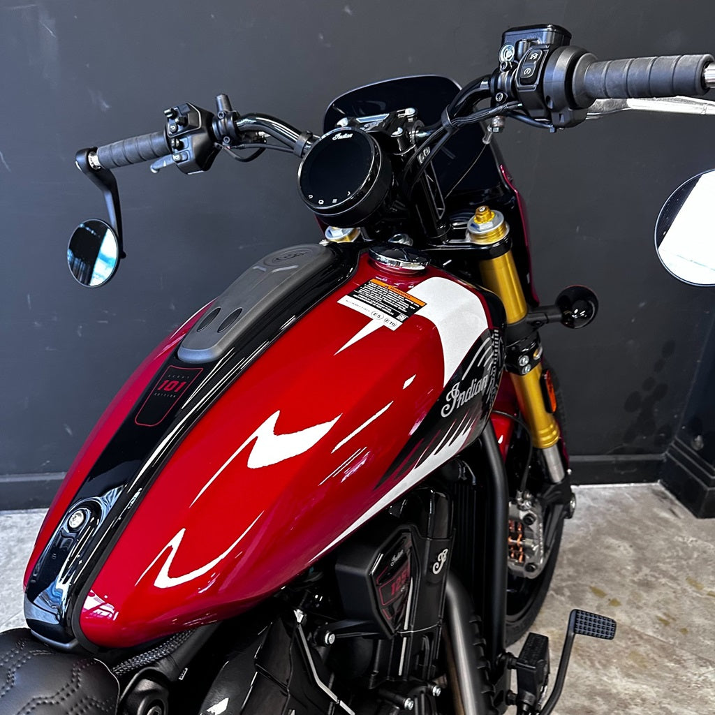 Red motorcycle with a black and white design on the fuel tank against a dark background