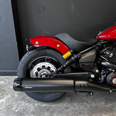 Close-up of a red and black motorcycle with 'Indian' branding on a gray surface.