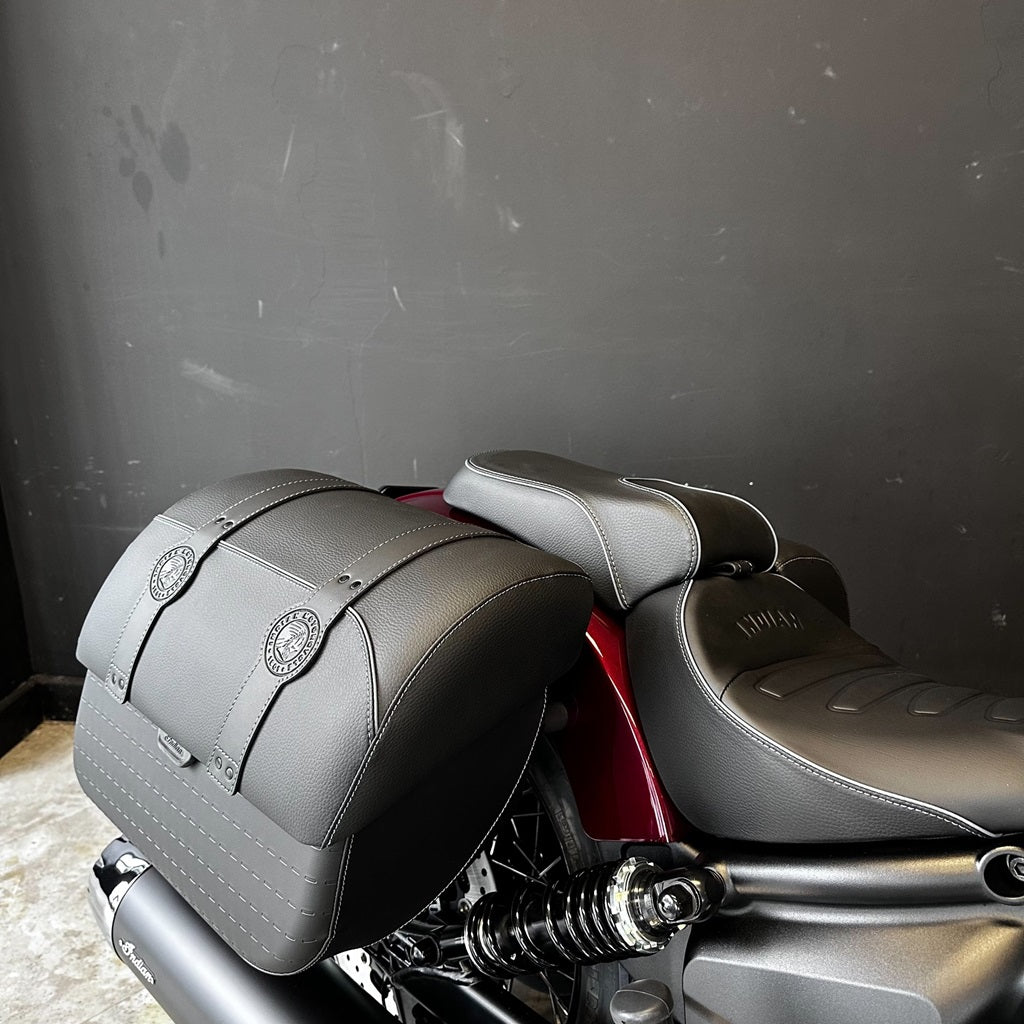 Gray motorcycle seat and saddlebags against a dark background