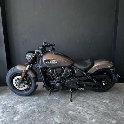 Motorcycle with 'Indian' branding on a gray floor against a black wall