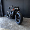 Black motorcycle parked indoors with a dark wall background