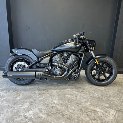 Black Indian motorcycle on a tiled floor with a dark wall background