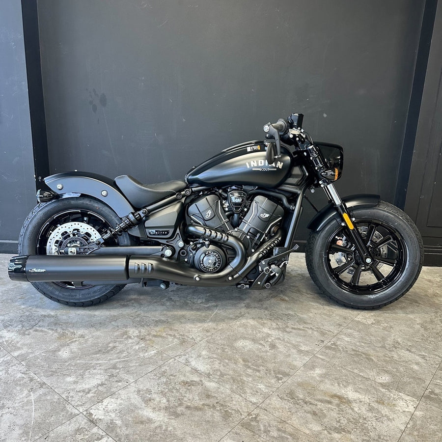 Black Indian motorcycle on a tiled floor with a dark wall background