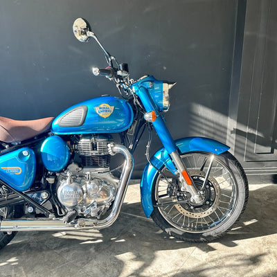 Blue motorcycle with visible branding parked on a concrete surface.