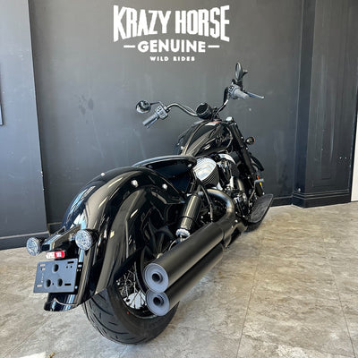 Black motorcycle parked in front of a Krazy Horse Genuine sign.