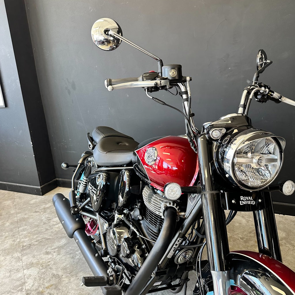 Red and black motorcycle parked indoors against a dark wall.