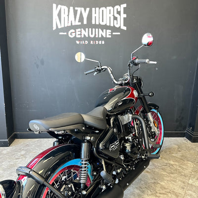 Motorcycle with 'Krazy Horse Genuine' branding on a dark wall.