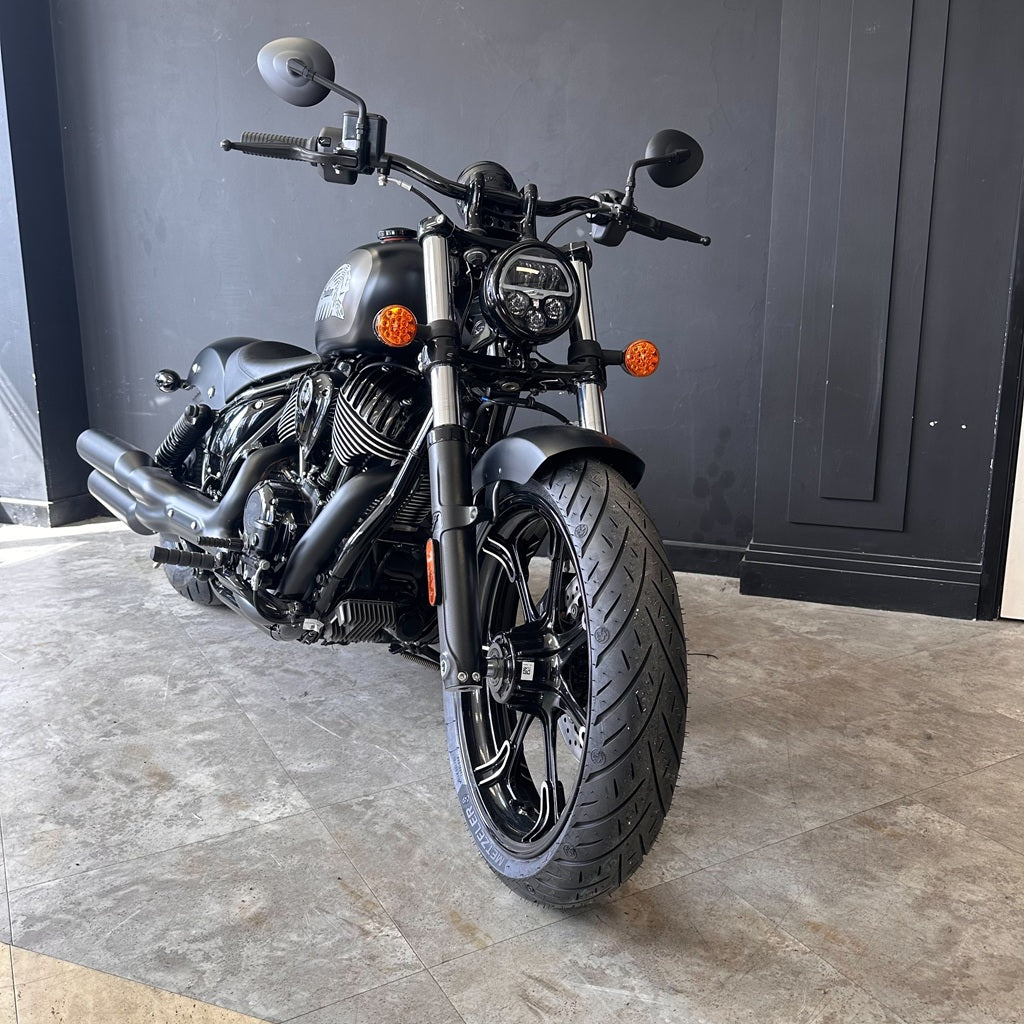 Black motorcycle parked indoors with a gray wall background