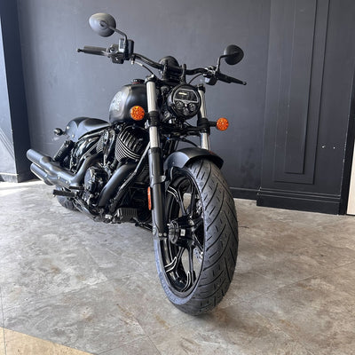 Black motorcycle parked indoors with a gray wall background