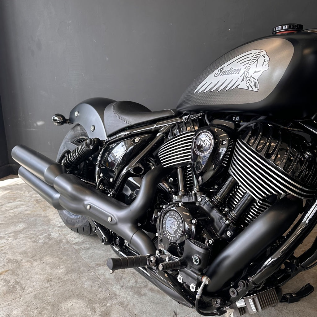 Close-up of a motorcycle engine with 'Indian' branding on a dark background