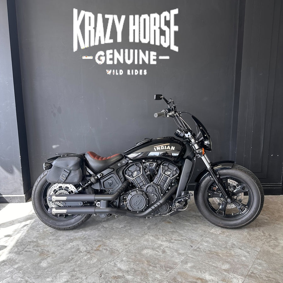 Motorcycle parked in front of a wall with 'Krazy Horse Genuine' branding.