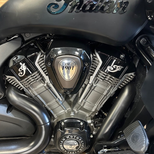 Close-up of a black and silver Indian motorcycle engine with the Indian logo on the fuel tank and a central badge reading 'CSI 1901'.