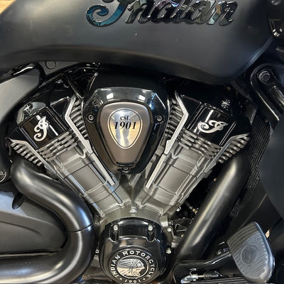 Close-up of a black and silver Indian motorcycle engine with the Indian logo on the fuel tank and a central badge reading 'CSI 1901'.