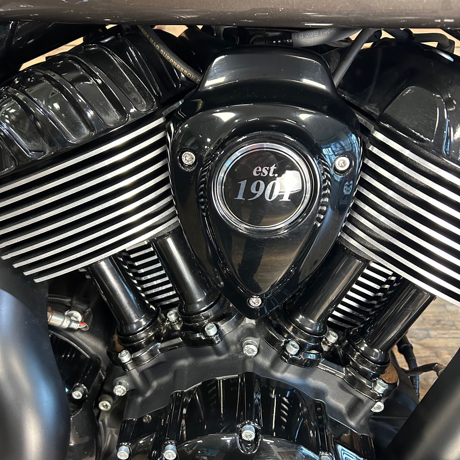 Close-up of a motorcycle engine with 'est. 1903' branding.