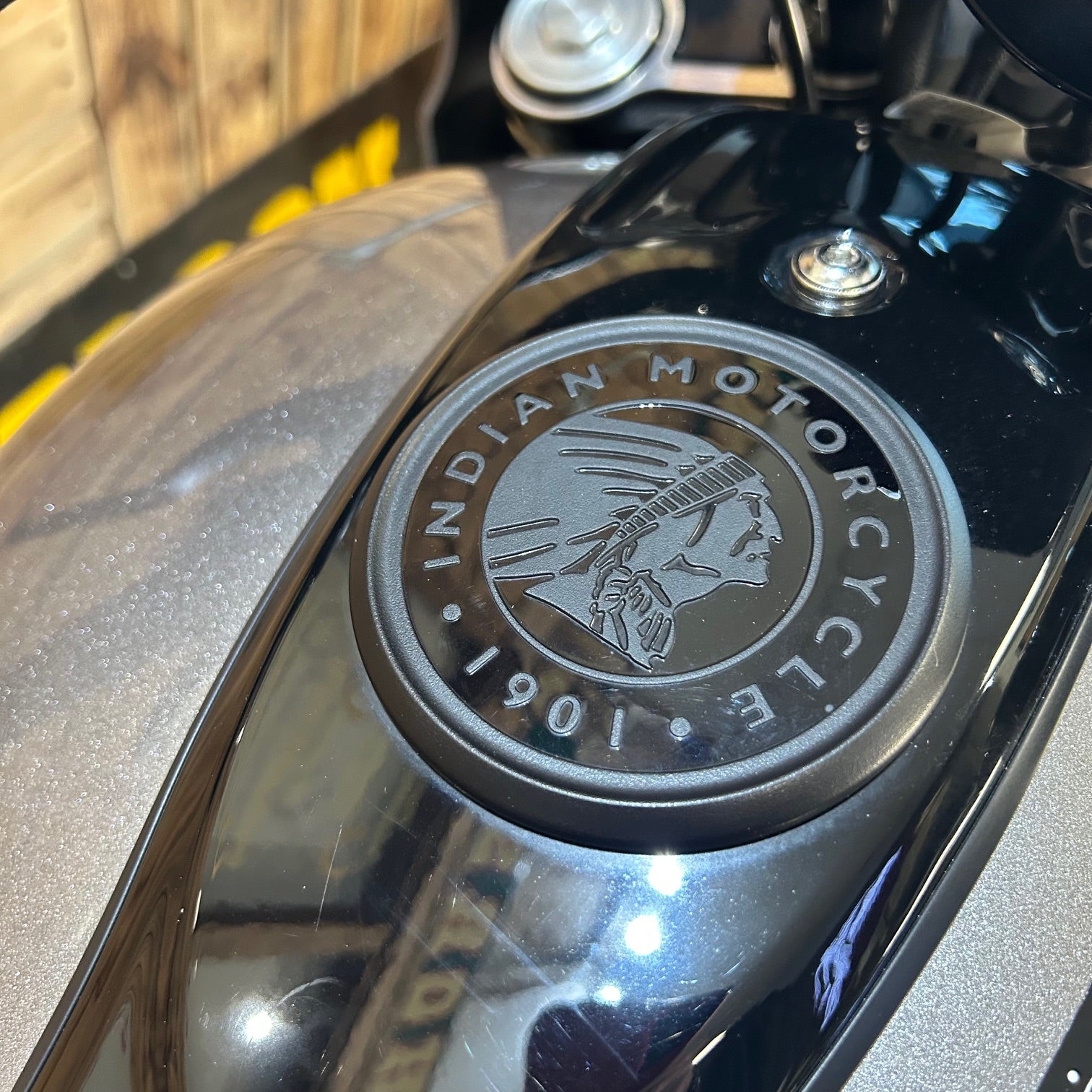 Close-up of an Indian Motorcycle logo on a black surface.