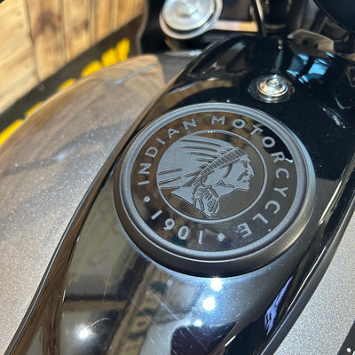 Close-up of an Indian Motorcycle logo on a black surface.