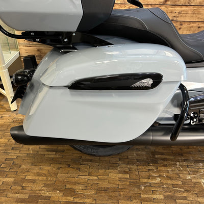 Gray motorcycle with a black exhaust on a wooden floor