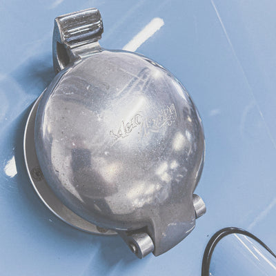Metallic object with 'Waltham' branding on a blue background